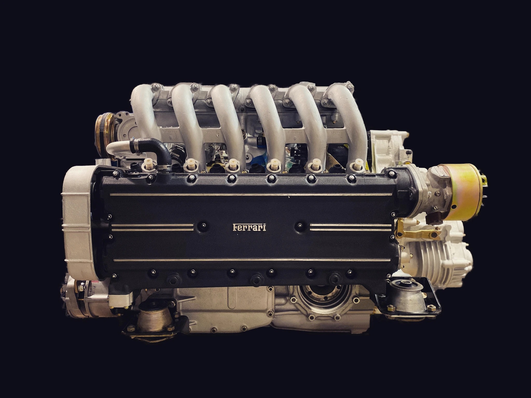 Detailed view of a restored Ferrari engine, showcasing the artisan craftsmanship and meticulous restoration work